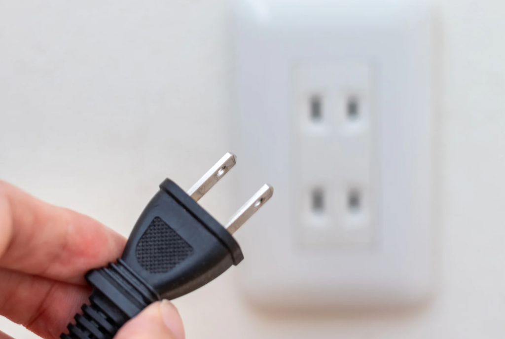 Unplugging devices from outlet to stop phantom load electricity waste at home