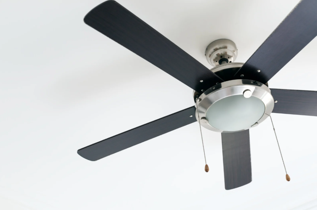 Energy efficient ceiling fan with light fixture installed on home ceiling to reduce air conditioning costs