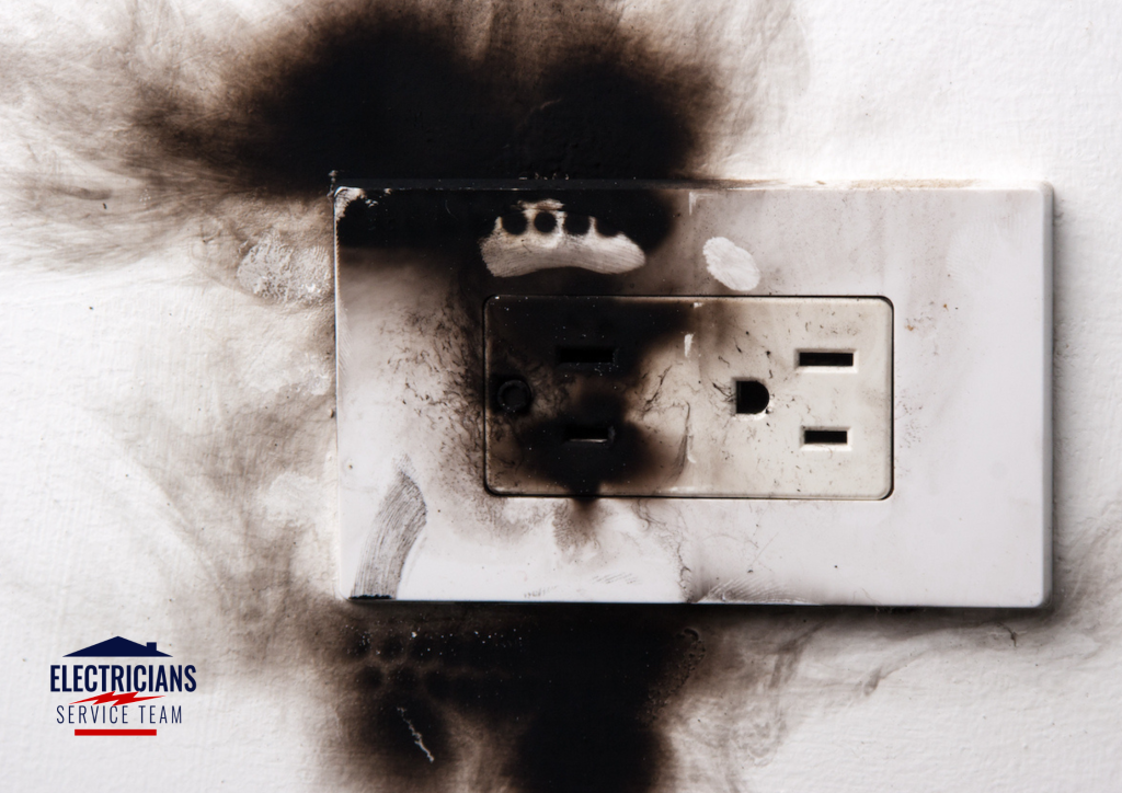 Burned and discolored electrical outlet caused by short circuit requiring immediate electrician repair
