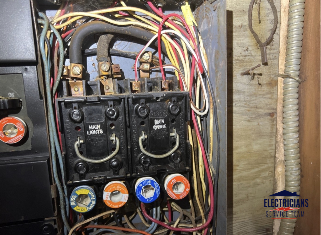 Old residential electrical fuse box that should be replaced with a modern circuit breaker panel