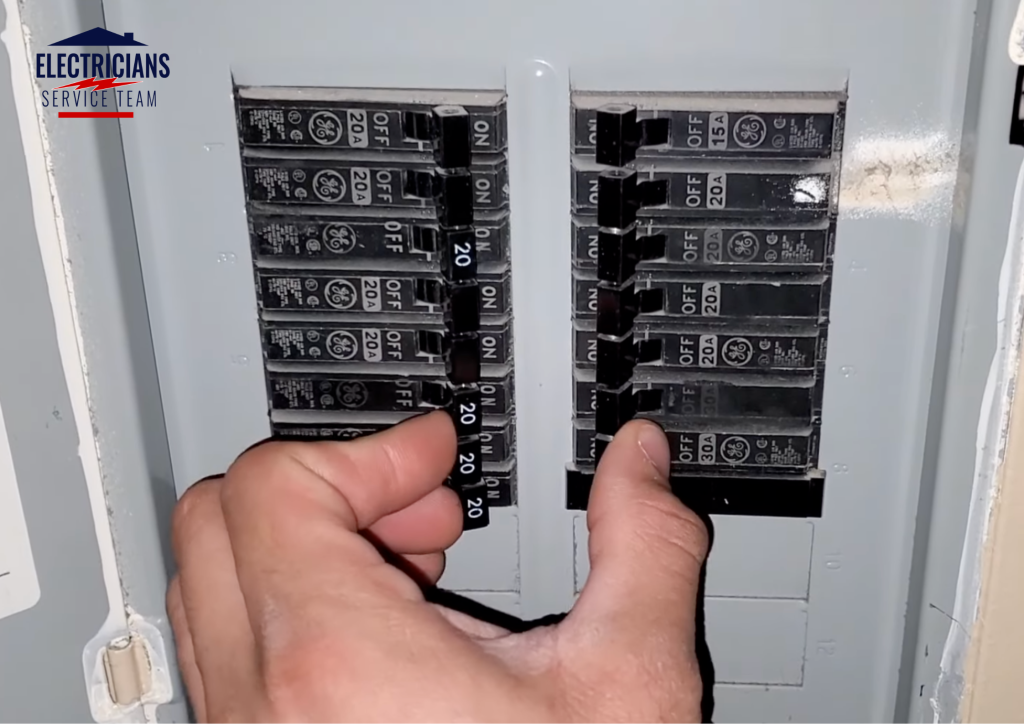  Licensed electrician inspecting GE circuit breaker panel with 20-amp and 30-amp breakers